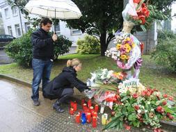 Los hijos del empresario Ignacio Uría colocan flores y velas en el lugar donde fue asesinado. / Archivo