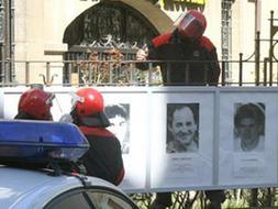 La Ertzaintza, siguiendo las órdenes de la Fiscalía, ha retirado las fotografías de presos etarras que colgaban de una verja del Banco Guipuzcoano en la localidad de Mondragón (Guipúzcoa). / Efe