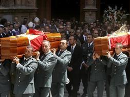 Momento del funeral presidido por los Príncipes de Asturias, cuando los compañeros de los agentes asesinados portaban sus féretros./ Efe