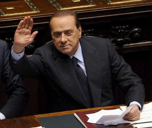 El primer ministro italiano Silvio Berlusconi saluda a sus diputados tras salvar con una mayoría simple la moción de censura presentada por la oposición contra el subsecretario de Justicia, Giacomo Caliendo./ Efe