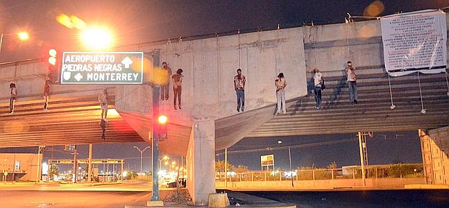 Fotografía donde se ven los cuerpos de nueve personas colgando de un puente en la ciudad de Nuevo Laredo. / Efe
