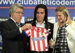 Falcao, junto a su esposa, recibe de manos de Cerezo una camiseta para el hijo que esperan, en su despedida del Atlético. / Efe | Atlas