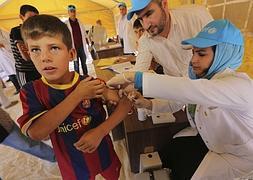 Un niño sirio refugiado es atendido por los servicios médicos en el campo de Qurn Gusik. / Efe