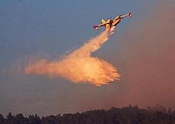 Un hidroavión realiza tareas de extinción en la zona. / Efe