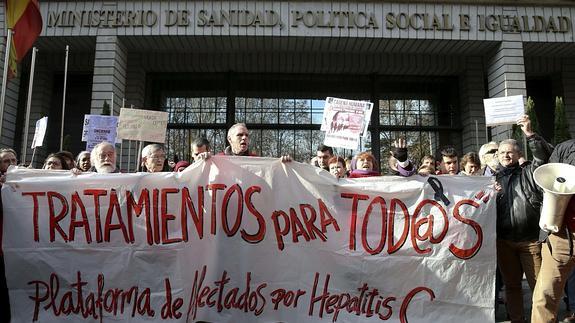 Varias personas participan en una cadena humana, organizada por la Plataforma de Afectados por la Hepatitis C, rodeando el Ministerio de Sanidad. 