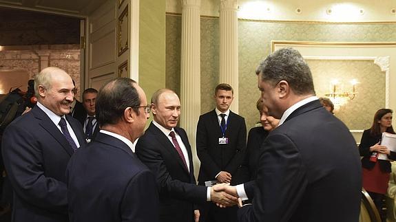 Poroshenko y Putin se estrechan la mano.