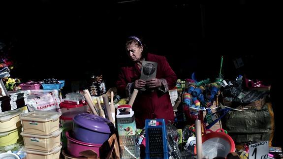 Una mujer compra artículos en una tienda de Atenas. 