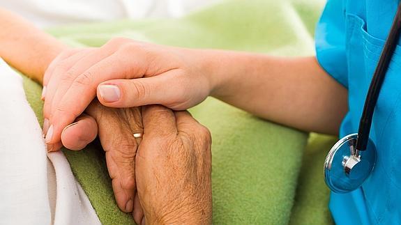 Una trabajadora social atendiendo a una paciente con alzheimer.