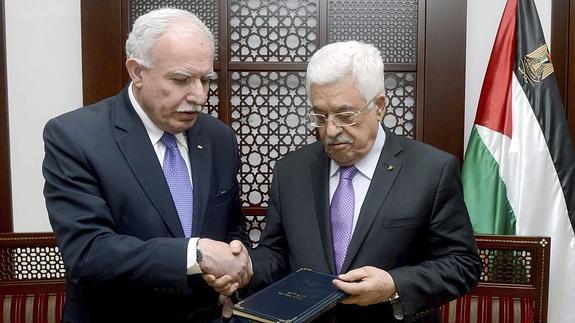 El presidente de la Autoridad Nacional Palestina, Mahmud Abás, recibe documentos del ministro palestino de Asuntos Exteriores, Riad al Maliki (izda). 