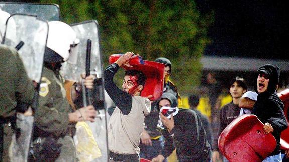 Ultras griegos se enfrentan a los antidisturbios.   