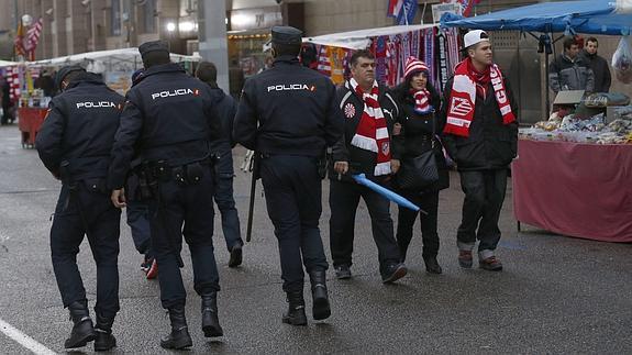 Policías y aficionados, en los aledaños del Vicente Calderón. 