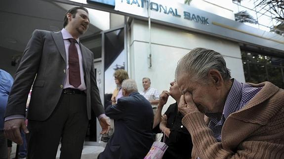 Un empleado de banca explica el corralito a unos jubilados.