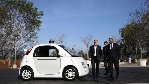 El presidente ejecutivo de Google, Eric Schmidt (izda.), observa el coche de su empresa.