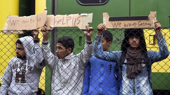 Refugiados piden ayuda para llegar a Alemania en la estación ferroviaria de Bicske. 