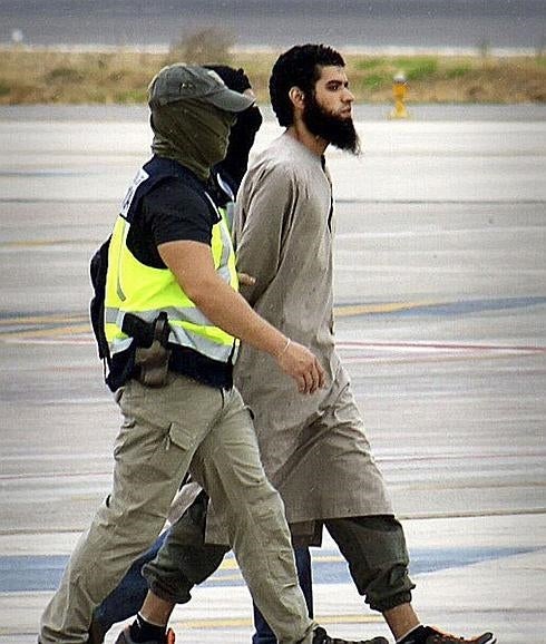 Policías custodian a un presunto líder de una célula del EI detenido en Melilla. 