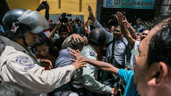 Un cordón policial separa a un grupo de seguidores del opositor venezolano Leopoldo López y otro grupo oficialista.