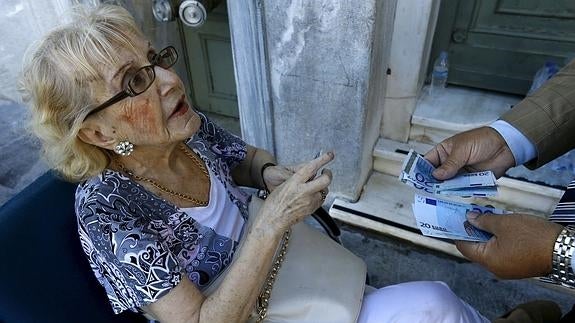 Una jubilada cobrando su pensión. 