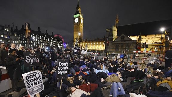 Varias personas se manifiestan contra la intervención del país en Siria frente al Parlamento británico.