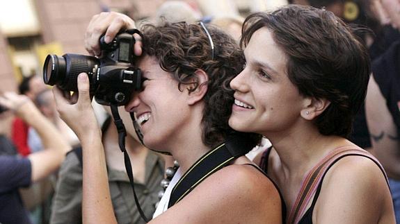 Una pareja de lesbianas saca una foto durante el desfile del 'Orgullo gay'.  