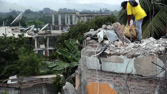 Un joven recupera objetos personales de su vivienda destrozada.