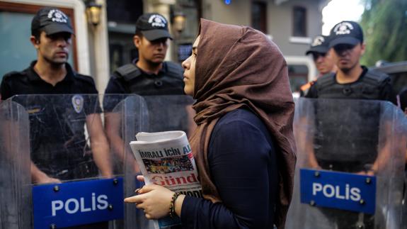 Una mujer sostiene un ejemplar del diario Özgür Gündem, clausurado por la policía turca.