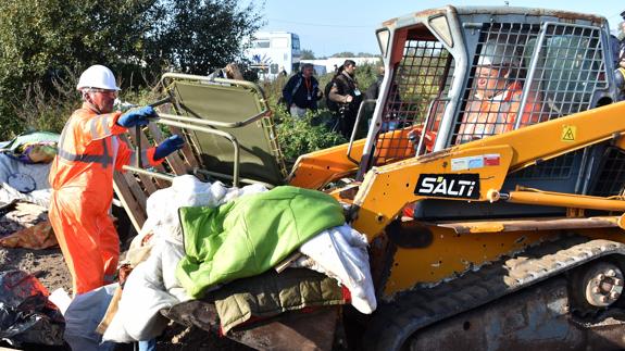 Operarios trabajan en la demolición de las chabolas. 