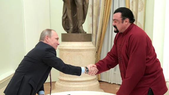 El actor Steven Seagal estrecha la mano de Vladimir Putin.