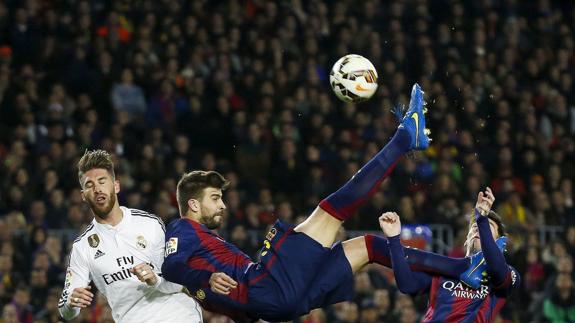 Gerard Piqué intenta una chilena ante Sergio Ramos en un clásico. 