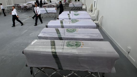 Trabajadores de la Funeraria San Vicente sacan los féretros de las víctimas. 