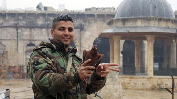 Un soldado sirio hace el símbolo de la victoria junto a la mezquita de Umayyad, en el este de Alepo.