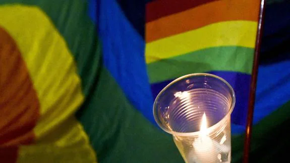 Bandera y velas en una manifestación del colectivo LGBT en Colombia.