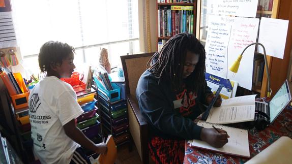 Ayinde (i) y Zion estudian en su casa. 