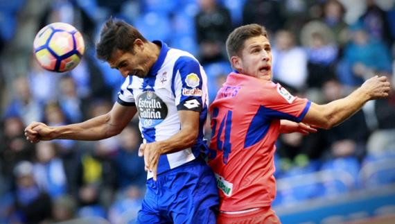 Celso Borges disputa un balón con Kravets. 