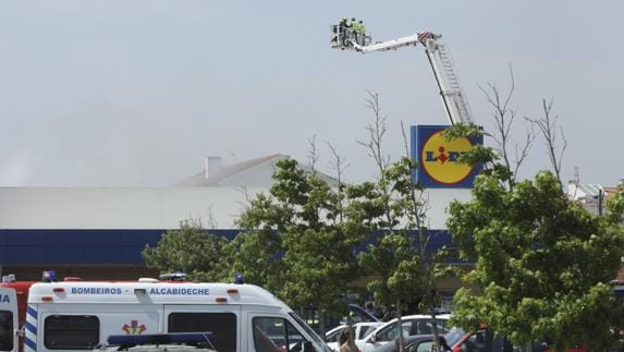 Bomberos trabajan en las labores de extinción de varios edificios en llamas tras estrellarse la avioneta.