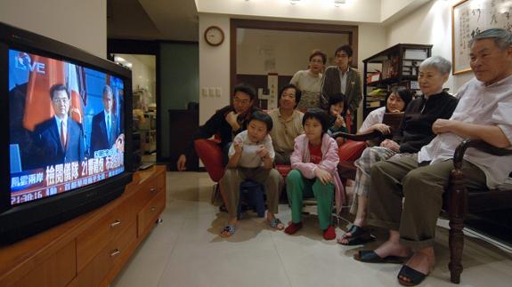 Una familia china sigue el telediario.