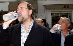 CALOR. Mariano Rajoy y Joaquín Ramírez beben agua durante su paseo por Mijas. / J. DOMÍNGUEZ. EFE