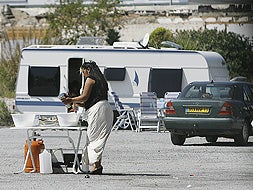 DE 'CAMPING'. En Córdoba, Granada y Almería se han dado casos similares            al de Málaga. En la foto, una mujer lava los platos en un barreño en el campamento Benítez. / SALVADOR SALAS