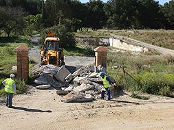 TRABAJOS. Los obreros cerraban ayer con tierra y escombros los accesos al campamento Benítez. / CARLOS MORET