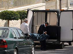 Empleados de la funeraria judicial trasladan el cadáver del empresario./ JOSELE-LANZA