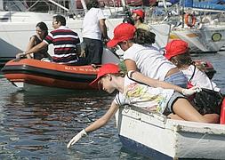 Una niña recoge un residuo del mar.:: Patricia Merchán