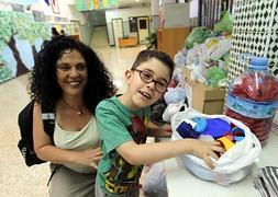 Jorge y su madre, con bolsas llenas de tapones en el colegio en el que estudia. :: JAIME GALLARDO