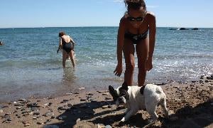 Una joven juega con su perro en la playa de La Sal. :: Selene Vega