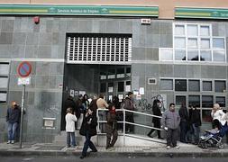 Varias personas permanecen a las puertas de una oficina del Servicio Andaluz de Empleo.:: Salvador Salas