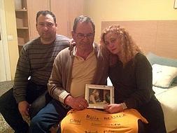 El padre de Ana, entre sus dos hijos, Antonio y Marian, sostiene una foto de la víctima. :: Galindo