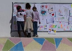 Tres niñas observan los murales que los alumnos han realizado para despedir a su profesora.:: Ñito Salas / Vídeo: Inma Pérez y Rossel Aparicio