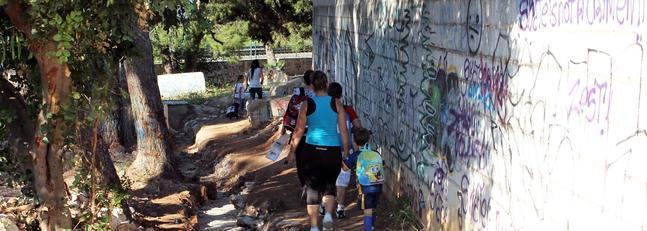 Vecinos de El Pinillo exigen asfaltar una vía intransitable de acceso a un colegio y a la parada de Cercanías
