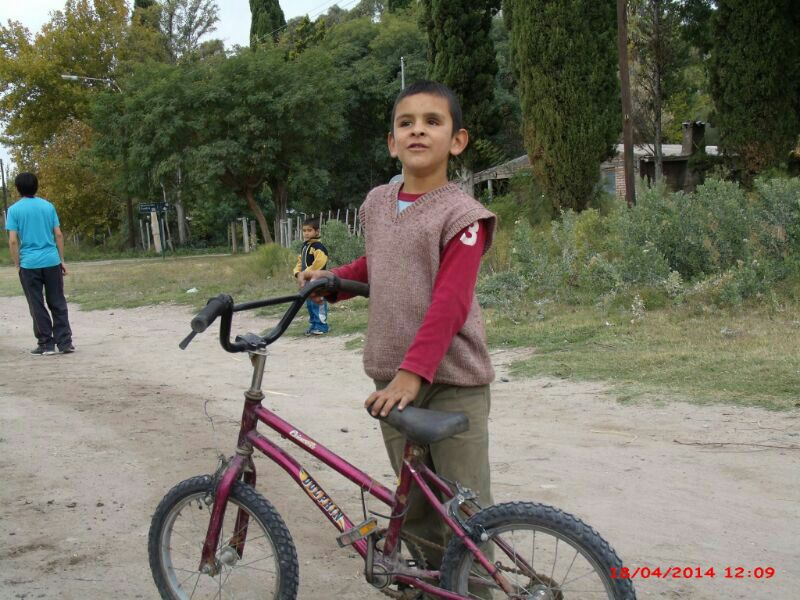 Ezequiel, con su bicicleta, que monta a pesar de sus limitaciones