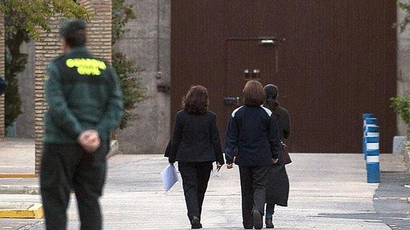 Dos funcionarias conducen a Isabel Pantoja al interior de la cárcel de Alcalá de Guadaíra.