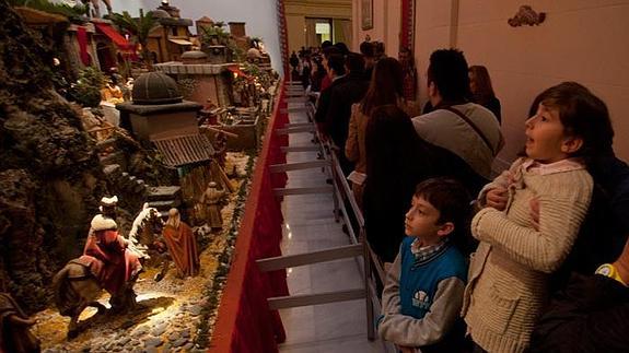 Unos niños contemplan el belén del Ayuntamiento.