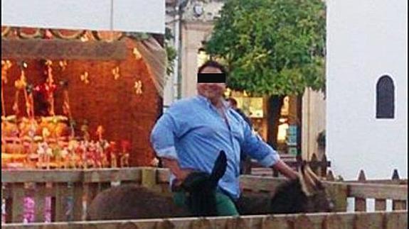 Foto distribuida por el Círculo Animalista de Podemos de un hombre sobre el burro que después murió.